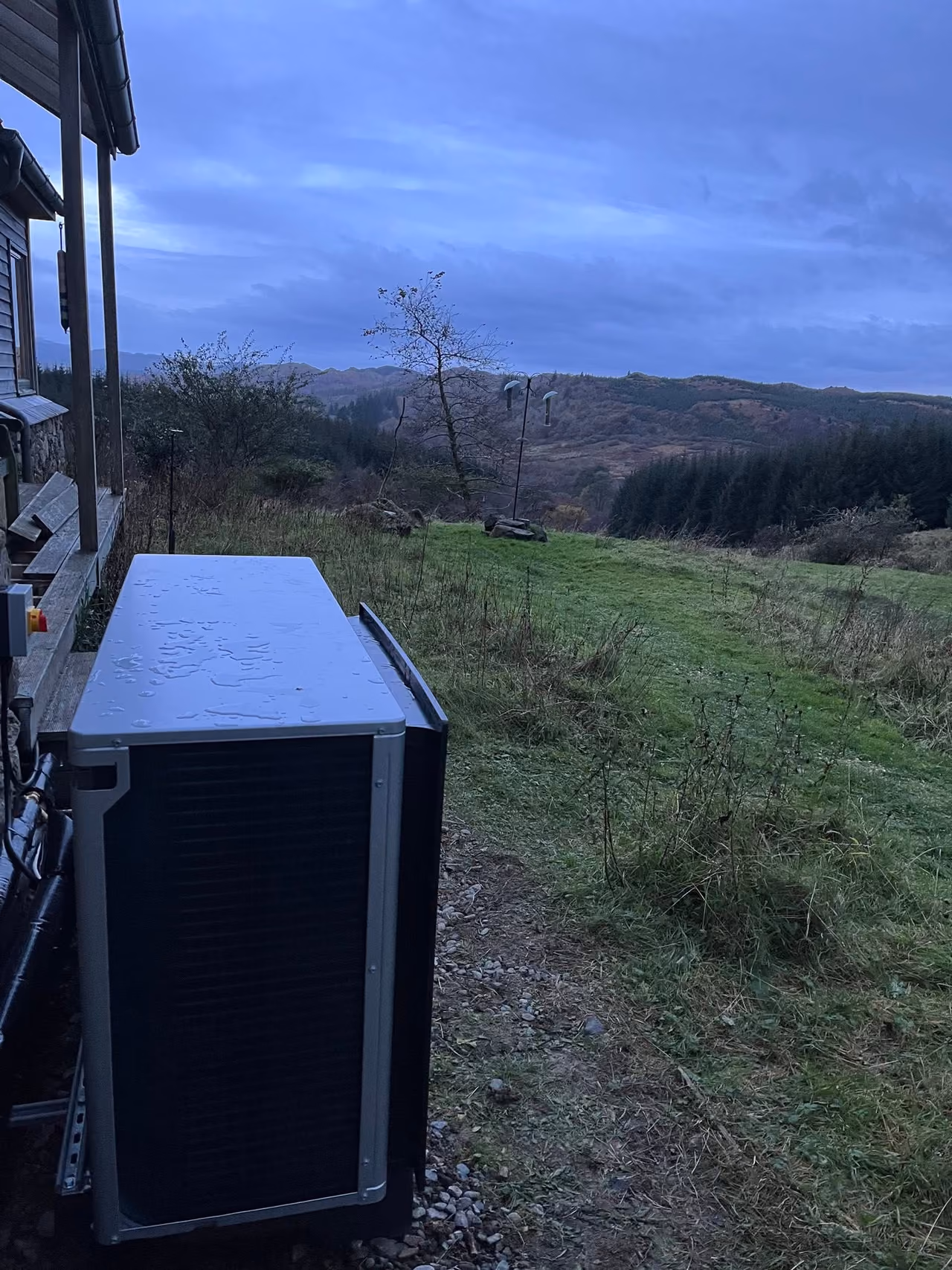 Air source heat pump installed at a rural hillside property